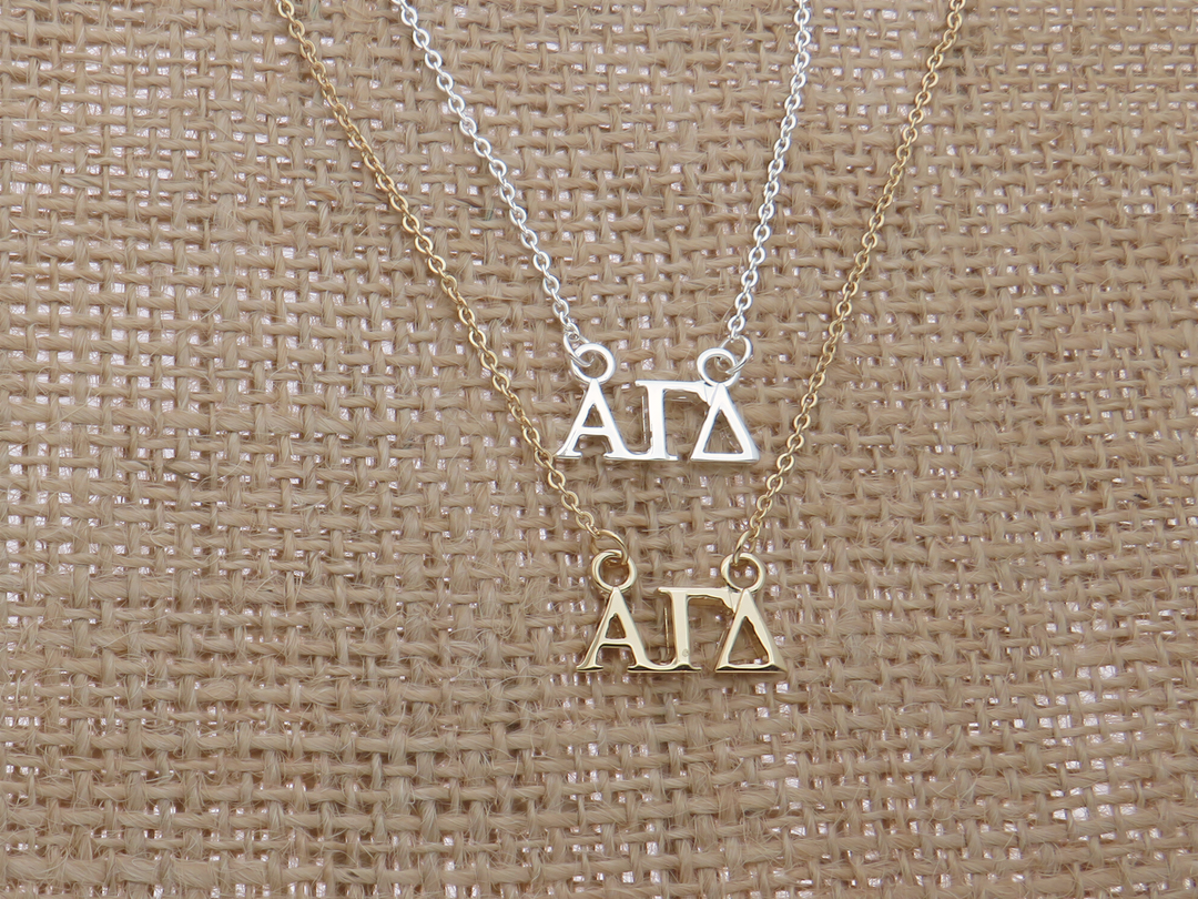 two necklaces with the letters 'A' and 'D' on them, arranged on a burlap background.