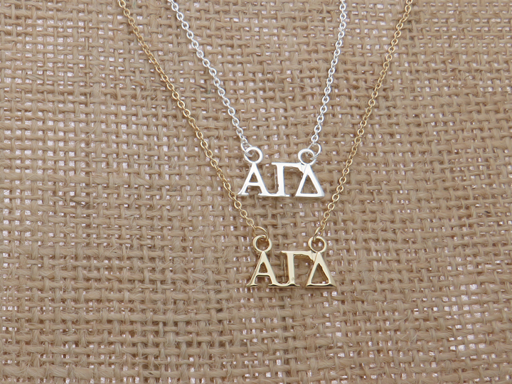 two necklaces with the letters 'A' and 'D' on them, arranged on a burlap background.