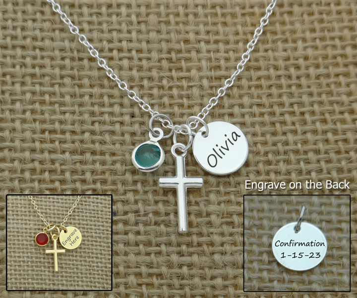 a silver necklace with a cross pendant and a charm with the name "Olivia" engraved on it. The necklace is displayed on a woven fabric background.