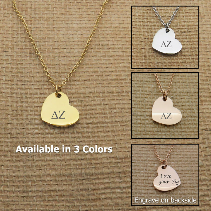 a necklace with a heart-shaped charm in three different colors: gold, silver, and white. The charm has the letters "AZ" engraved on it.