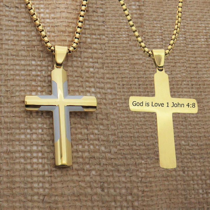 two gold-colored cross necklaces with religious text engraved on them.