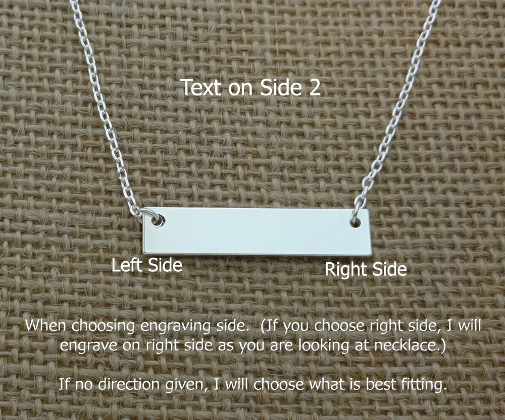 A necklace with a rectangular engraved bar on the left side, placed on a woven surface.
