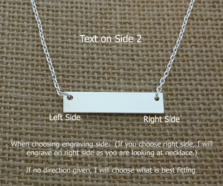 A necklace with a rectangular engraved bar on the left side, placed on a woven surface.