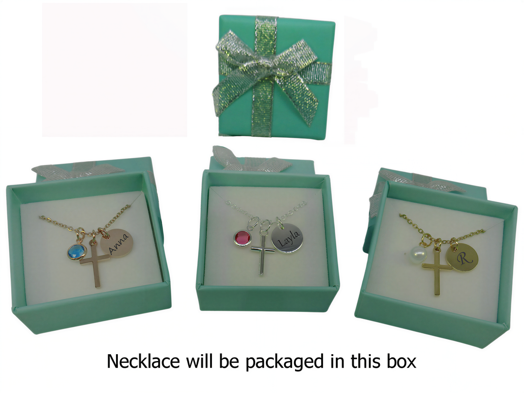 three green boxes containing necklaces, each with a cross charm and a name charm. The necklaces are packaged in the box, and the text indicates that the necklace will be packaged in this box.