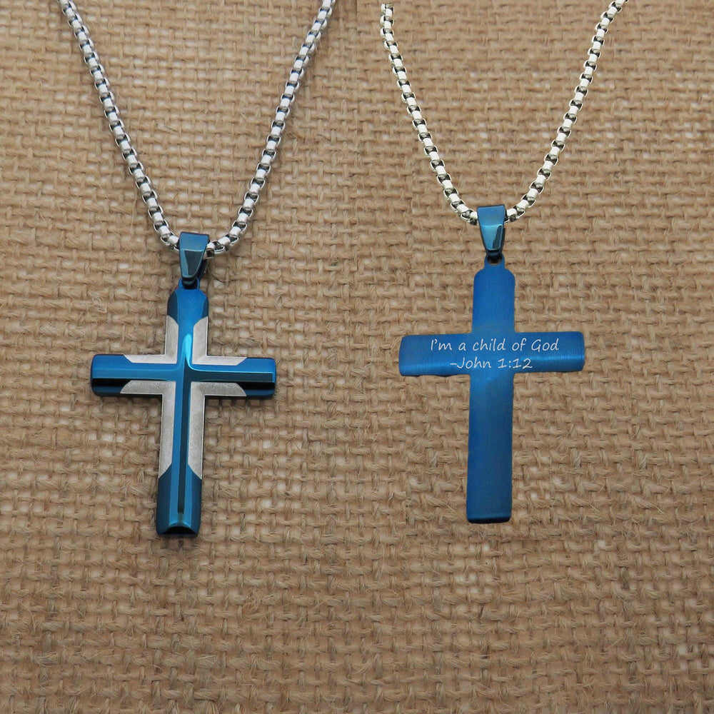 Two blue cross necklaces with silver chains, each featuring a religious message engraved on them.