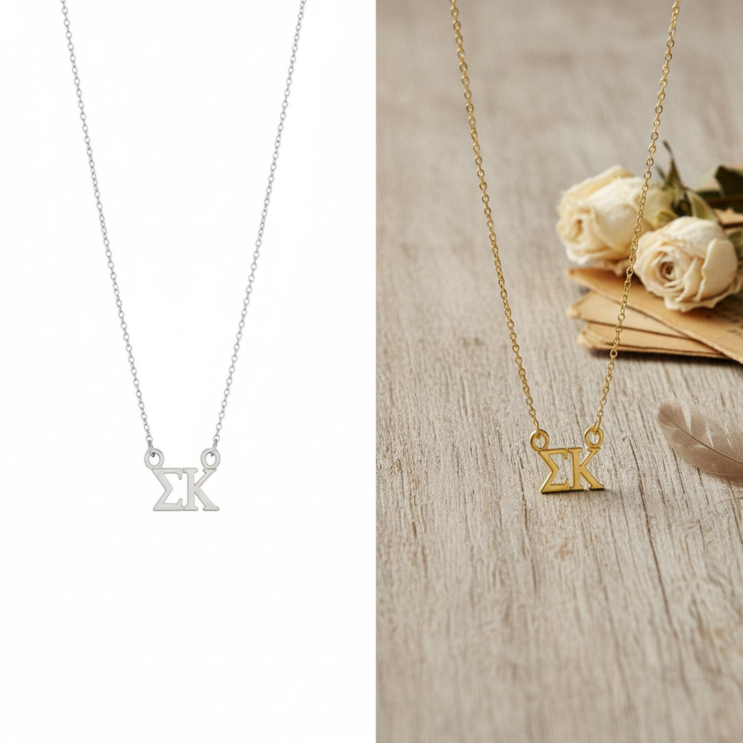 two necklaces, one silver and one gold, with the gold necklace featuring a small pendant in the shape of the Greek letters 'ΔΕΥΝ'.